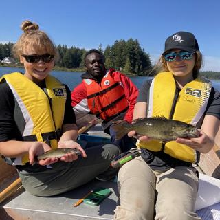 Fish & Aquaculture students in a boat holding fish