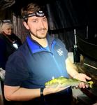 man wearing head lamp holding fish